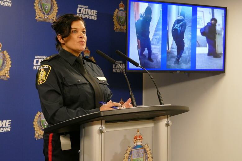 A woman in a police uniform speaks at a podium.