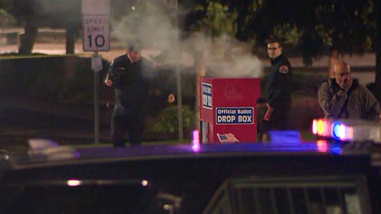 Smoke billows from a red ballot box.