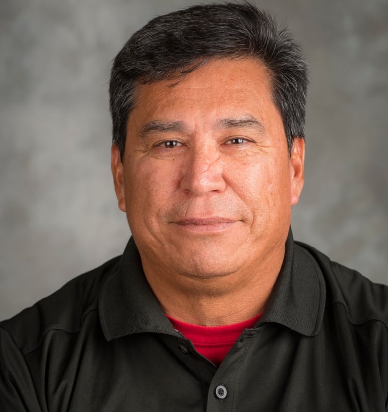 A headshot of a man in a collared shirt.