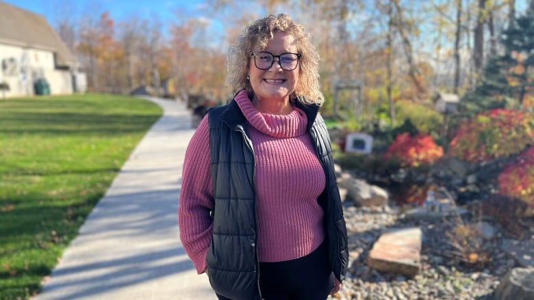 Tonya Crosby on a path beside a rock garden.