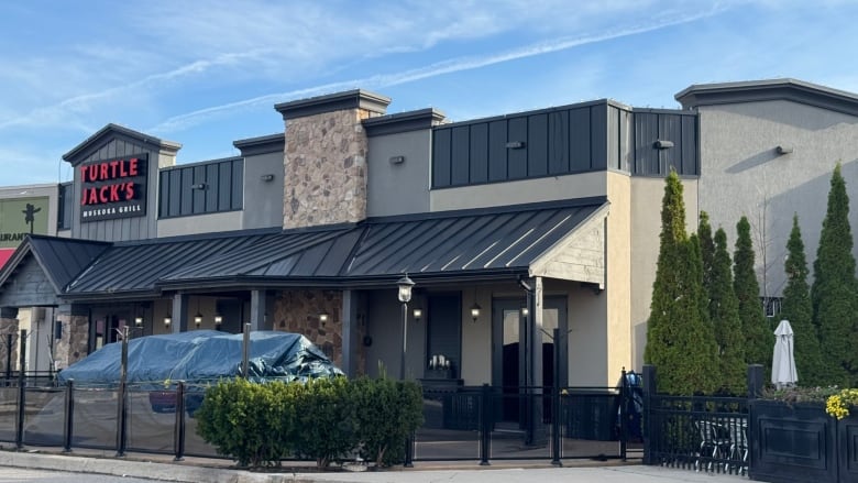 A building with a side patio features the words Turtle Jacks Muskoka Grill in capital letters.