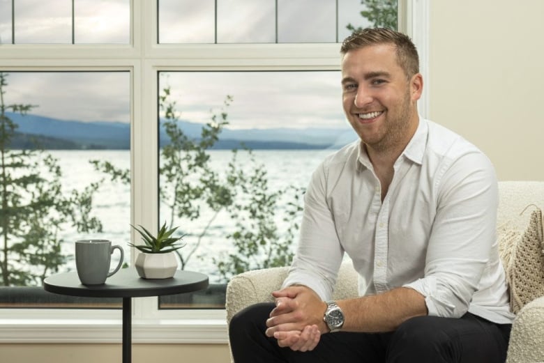 A man in a button down shirt smiles. 