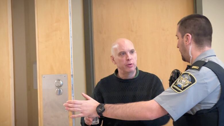 Daryl Digout is shown speaking with a sheriff during a break in proceedings at the Port Hawkesbury courthouse on Tuesday. 