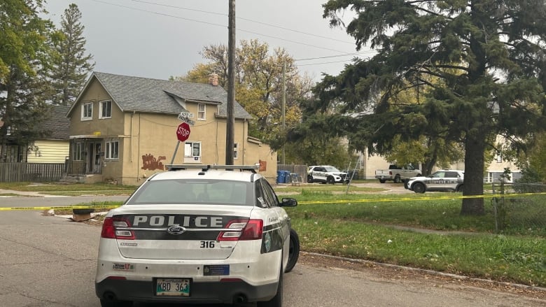 A white cruiser is outside of a home in Winnipeg.