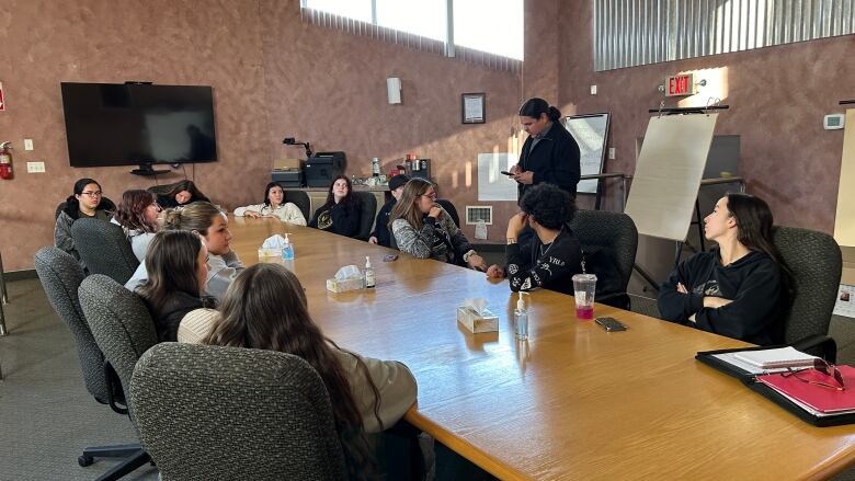 Youth sitting at boardroom table