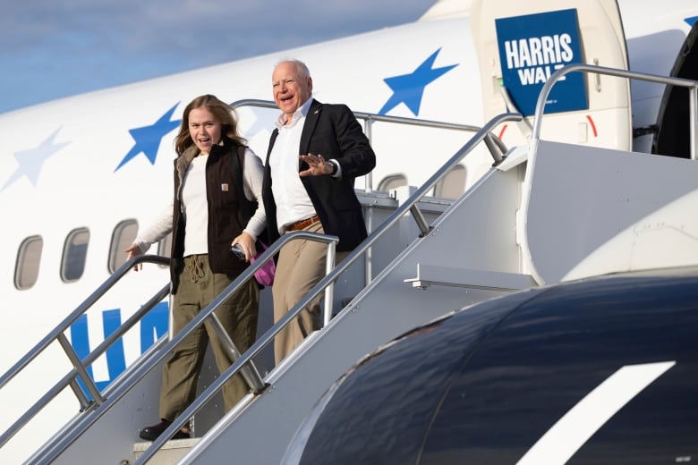 A man and a woman walk off an airplane