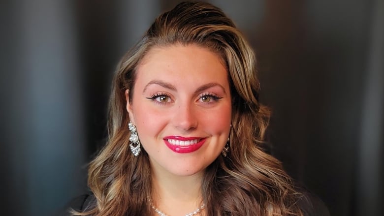 A smiling woman with curled blond hair and bright red lipstick.