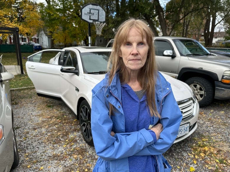 A woman in front of a car