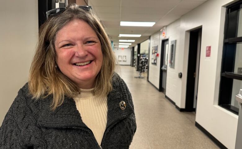 A woman smiling in a hallway 