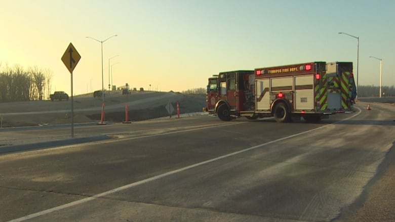 A fire truck blocks a road leading to an overpass.