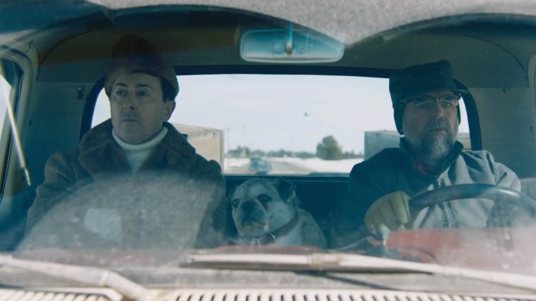 Two men in the cab of a pickup truck