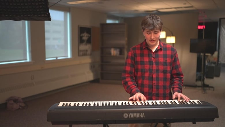 A boy playing a keyboard