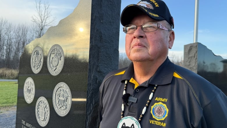 Vet stands beside memorial. Stones mark veterans and Code Talkers.