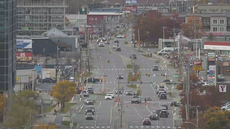 an intersection with vehicles. police vehicle blocking entrance.