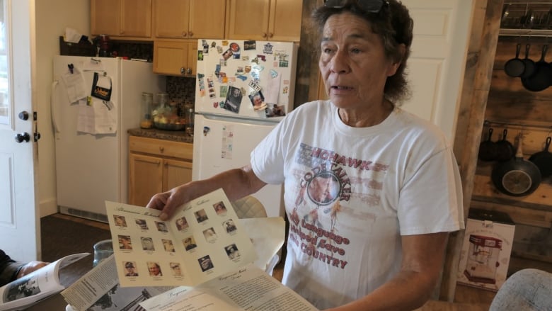 Woman holds old code talking book.