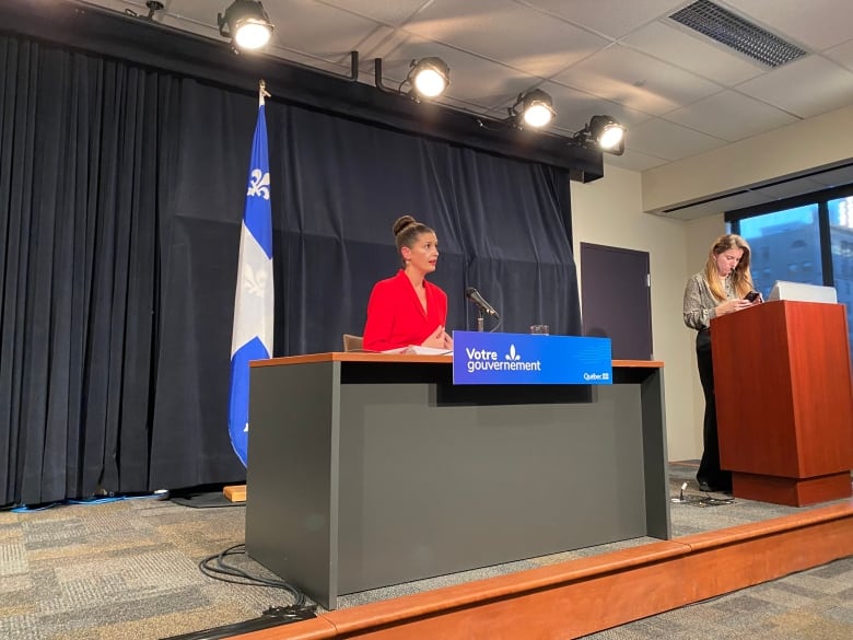 Genevive Guilbault sat behind a desk with a microphone during a news conference.