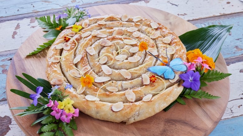 A large, circular golden brown pastry that resembles a coiled snake.