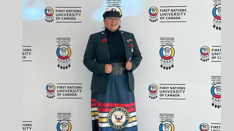 A photo of an Indigenous woman with a US Navy uniform and ribbon skirt.