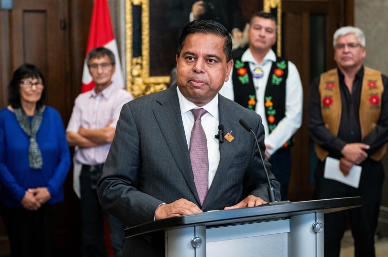 A man stands at a lectern.