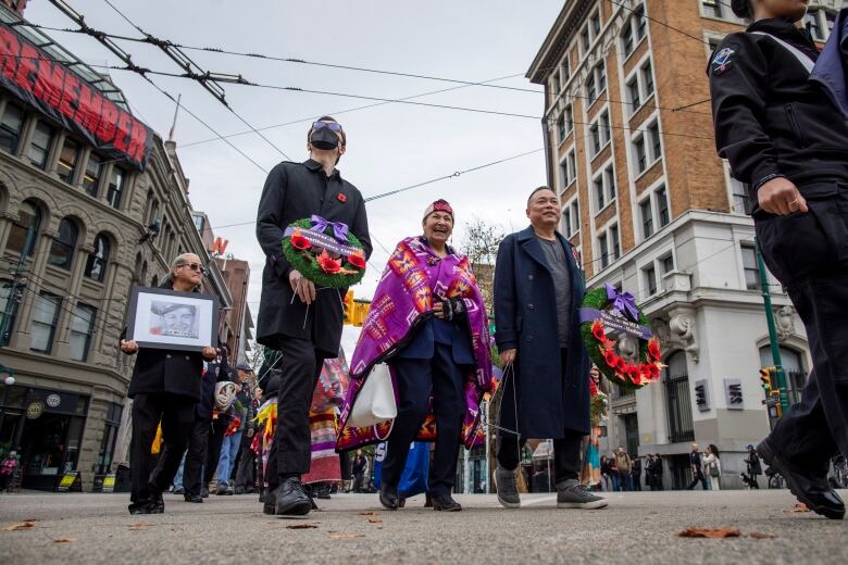 Dignitaries are pictured marching down East Hastings street towards the Victory Square Cenotaph in honour of National Indigenous Veterans Day in Vancouver, B.C, on Friday, November 8, 2024.