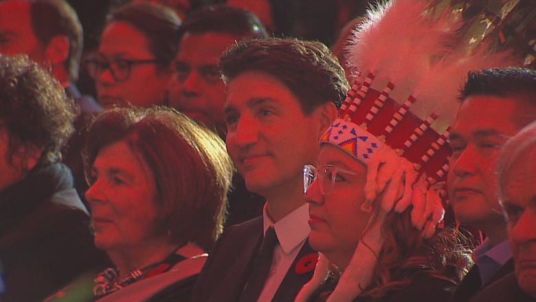 Profile of a man smiling in a crowd.