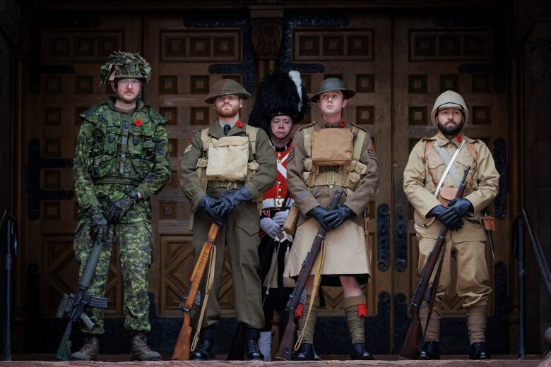 Photo of four soldiers wearing uniforms from various historical periods