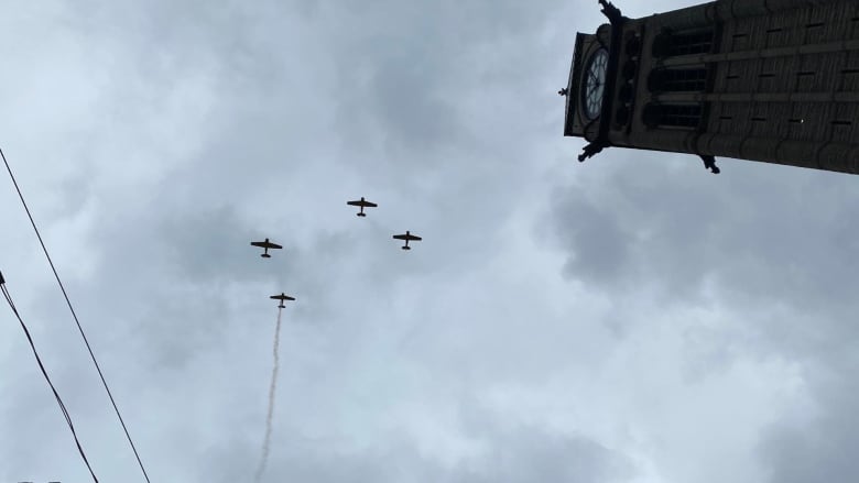 Photo of 4 planes flying in the sky near a clock tower