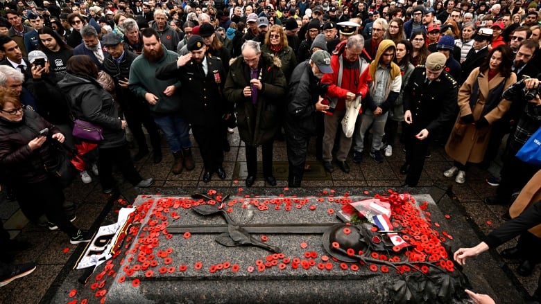 People place poppies on the Tomb of the Unknown Soldier after the Remembrance Day ceremony at the National War Memorial in Ottawa, on Monday, Nov. 11, 2024.