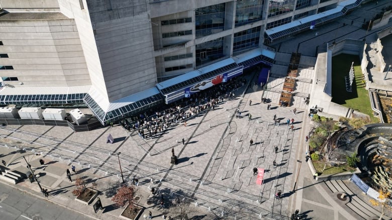 Aerial drone still of Rogers Centre, showing lineup for merch store as well as the giant friendship bracelet sign that reads: Taylor Swift The Eras Tour.