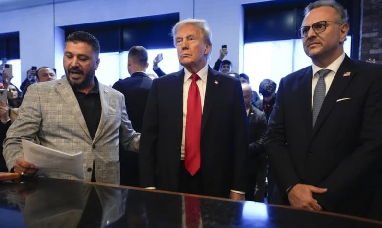 Donald Trump listens to Albert Abbas, owner of The Great Commoner, left, as Massad Boulos looks on during a visit to a cafe in Michigan in Nov. 2024. 