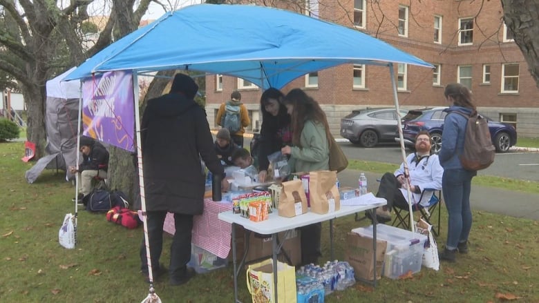 A tent with volunteers giving out juice boxes.