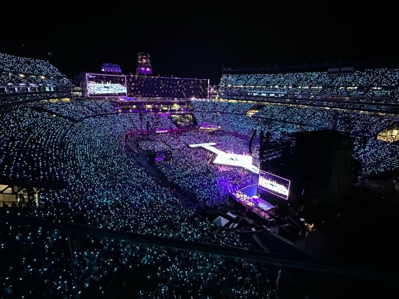 A huge concert venue lit up with purple lights