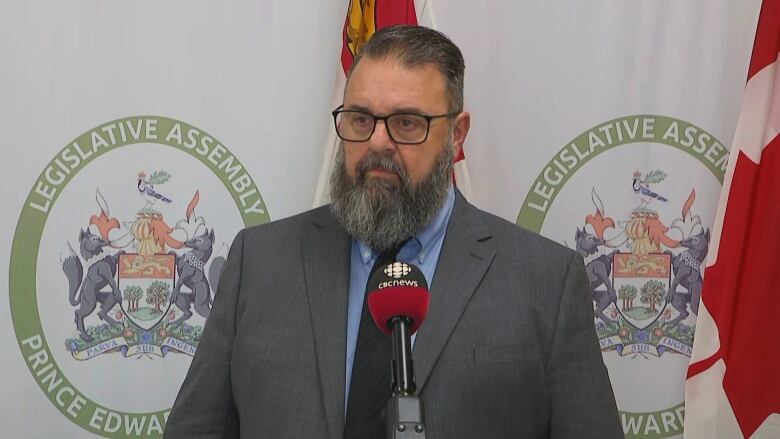 Man with large beard speaking into CBC microphone.