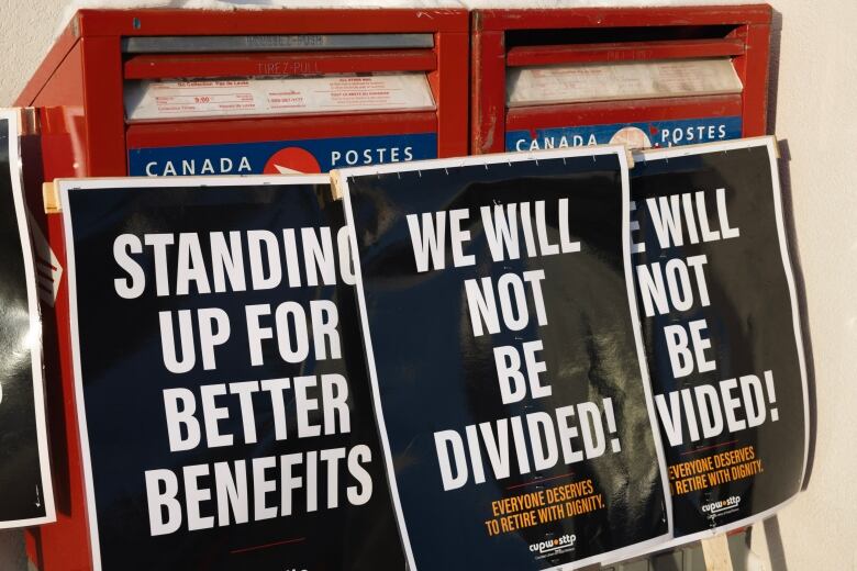 Strike signs lean up against a mail box