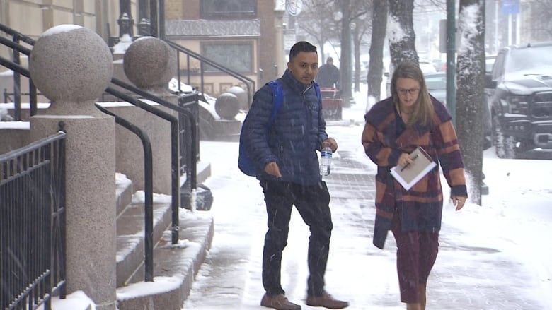 A young man walks outside a courthouse.