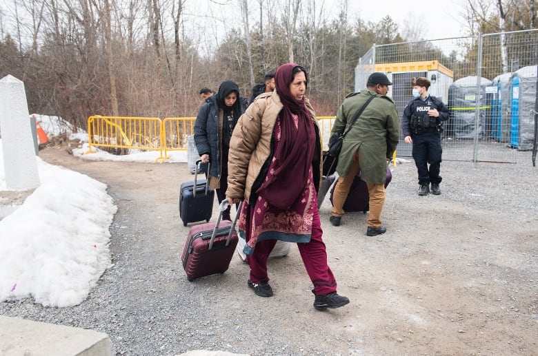 Asylum seekers enter Canada via Roxham road on the Canada/US border in Hemmingford, Que., Saturday, March 25, 2023.