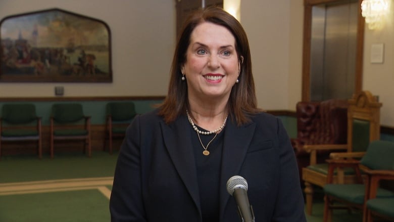 Woman wearing all black with long brown hair.