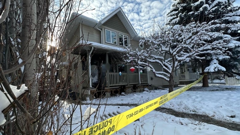 A house is pictured with police tape out front.