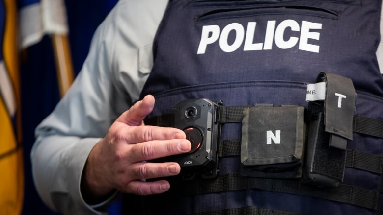 A person wearing a police vest and a body camera.