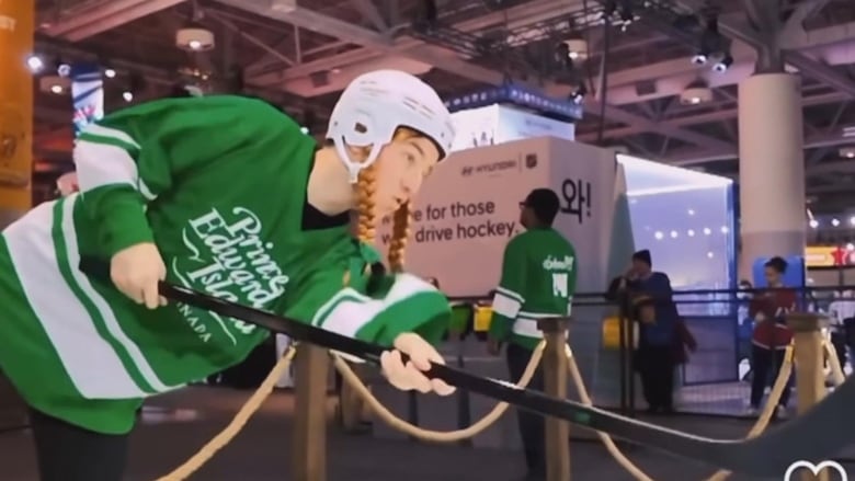 A player in a Green P.E.I. jersey and Anne of Green Gables pigtails takes aim at the NHL Fan Fair during the 2024 all-star game in Toronto.