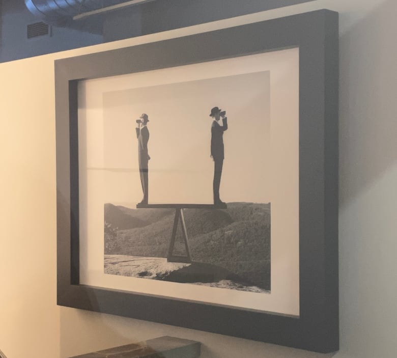 A photo of two men on a see-saw is framed in a law firm's office.