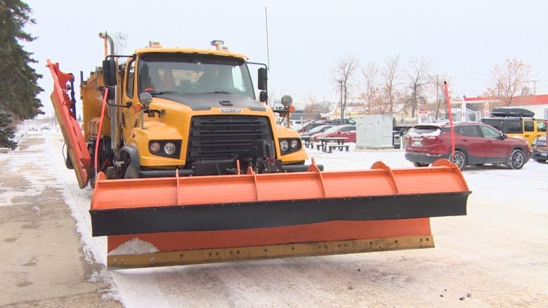 A snow plow is outside during the winter.