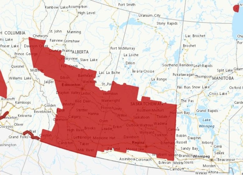 Map shows red zones on Alberta and Saskatchewan representing snow warning areas.