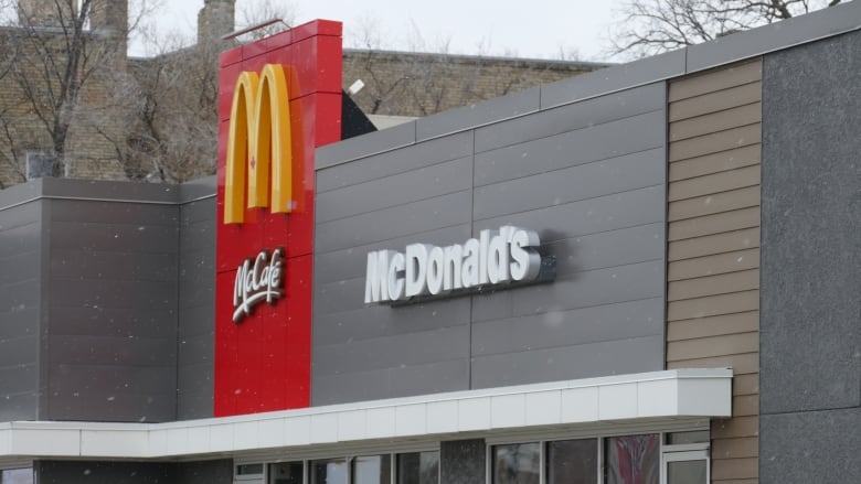 Snowflakes fall over a McDonald's fast foot restaurant sign. 