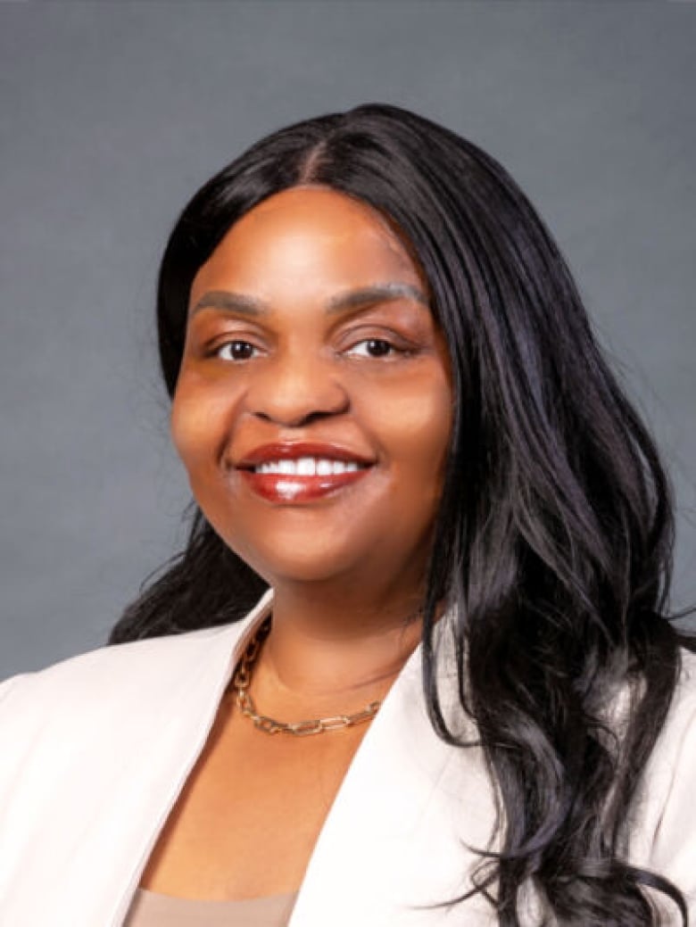 A Black woman smiles in a portrait.