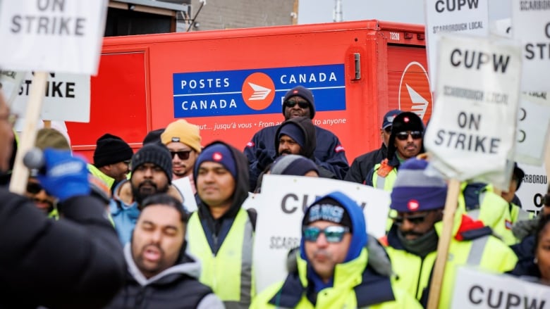 Picketers hold signs reading 